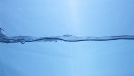 Vista-Macro-De-Dinámica-De-Fluidos-De-Gotas-De-Agua-Dulce-En-Movimiento-Sinfonía-De-La-Naturaleza-Efecto-De-Ondulación-Del-Agua-En-Cámara-Lenta-En-Tono-Azul