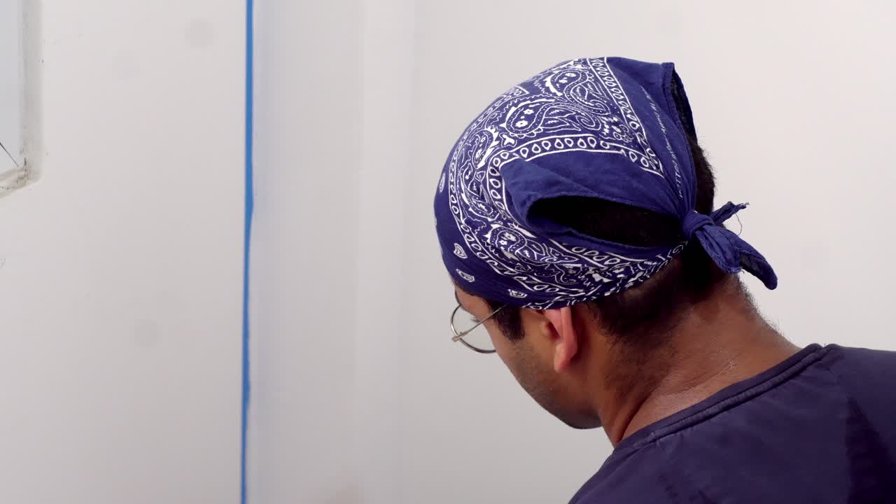 pintor aplicando pintura en la pared con el pincel - de cerca