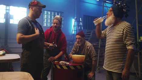 men socializing and enjoying drinks and snacks in a workshop
