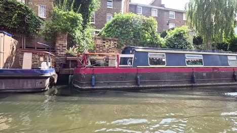 narrowboats passing by lush greenery in camden