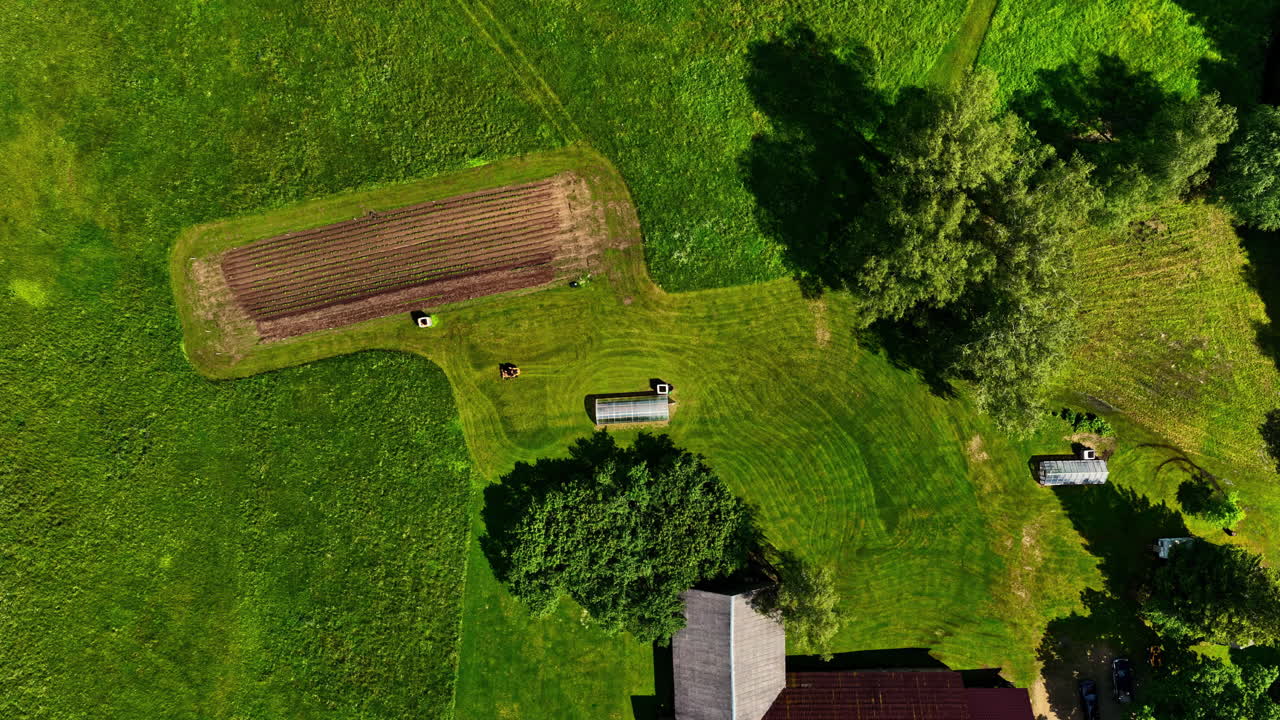 Lawn mower mowing the lawn of a plot of land. Aerial time lapse