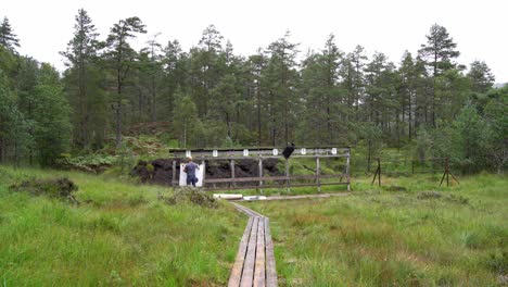 Man-preparing-targets-at-shooting-range---Big-black-and-white-paper-targets-put-up-on-wooden-stand-with-natural-forest-background