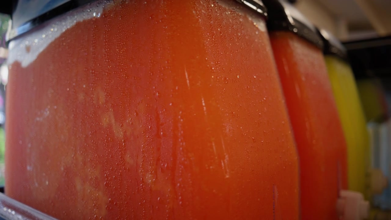 Deretan mesin es serut dingin menampilkan minuman beku yang menyegarkan dalam berbagai rasa cerah, ideal untuk penyegar musim panas.
