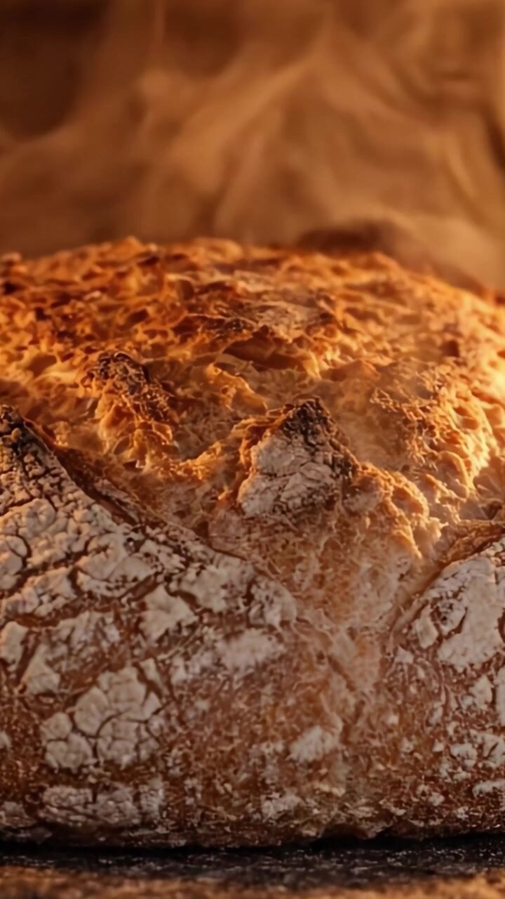 Golden Crusty Bread Emerging from the Oven, Capturing the Essence of Freshly Baked Goodness with Steam Rising, Showcasing Artisan Baking Craftsmanship and Texture
