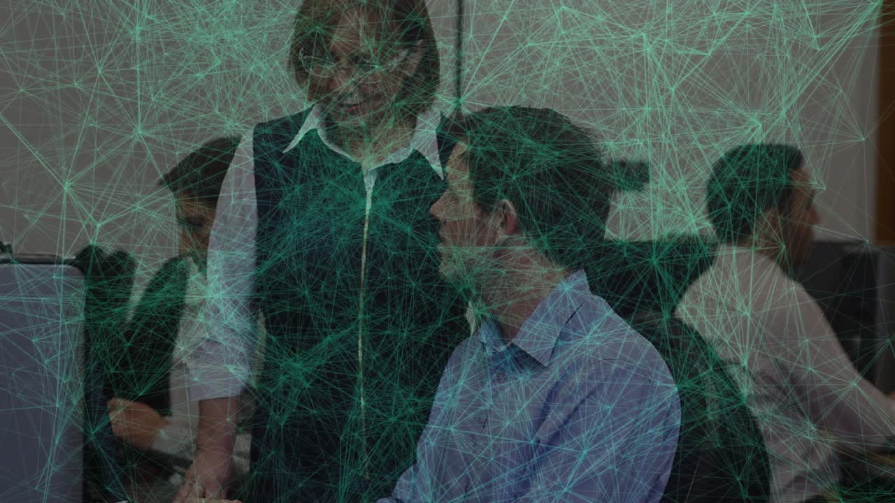 Female supervisor leaning over male employee at office desk with animated pointer guiding task