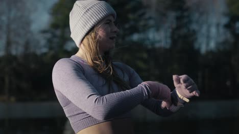 primer plano de una joven mujer caucásica calentándose al aire libre en invierno.