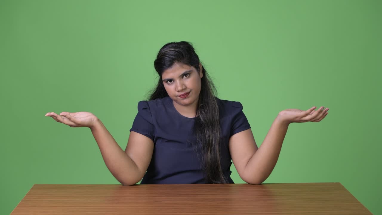 joven sobrepeso hermosa mujer de negocios india contra fondo verde