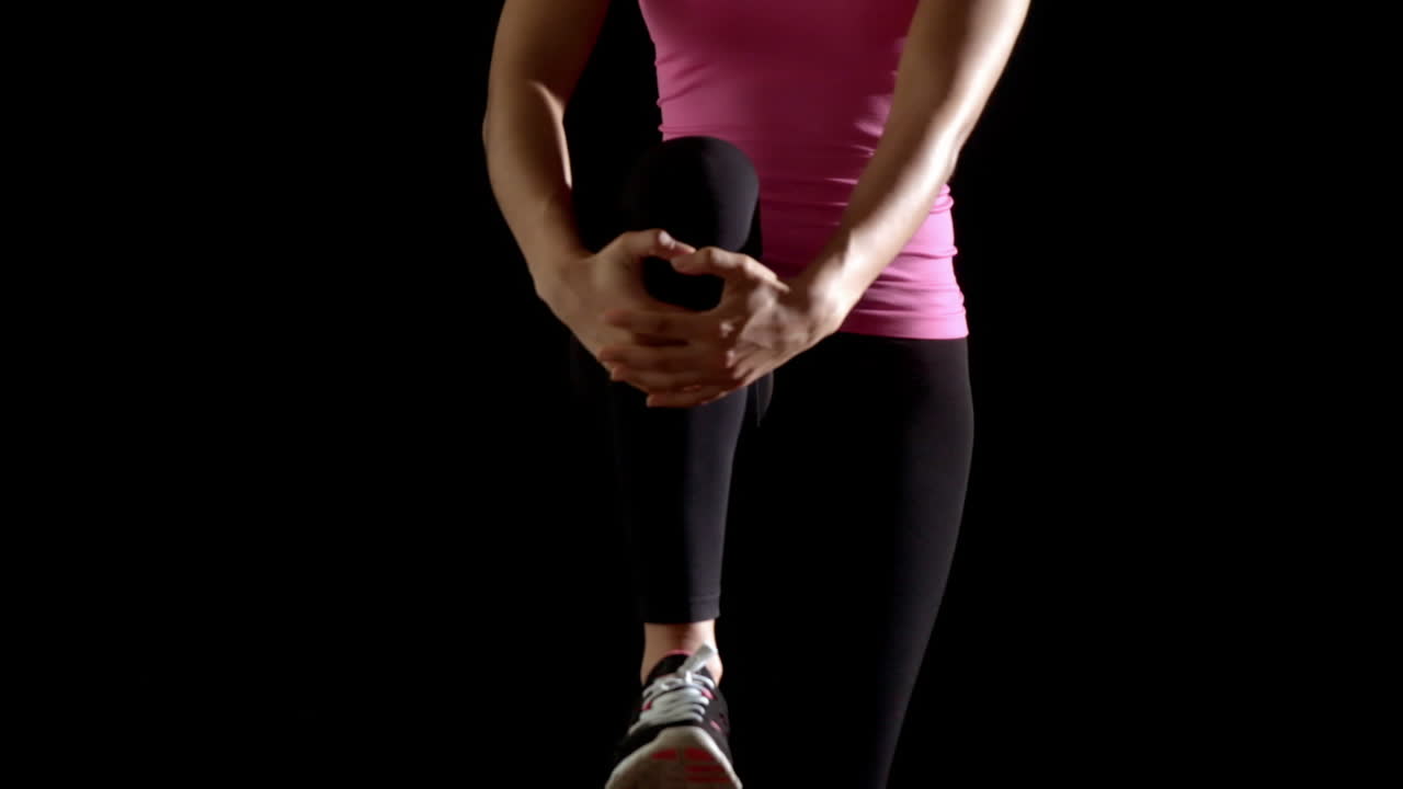 Fit woman in pink stretching leg