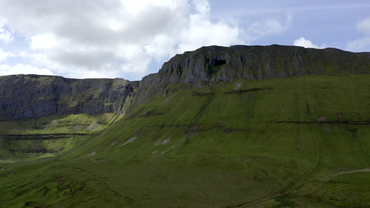Diarmuid and Grainne's cave in Sligo, Ireland, June 2021. Drone gradually orbits around the base of the Gleniff Horseshoe mountains facing south-west looking up at the cliffs of Annacuna.