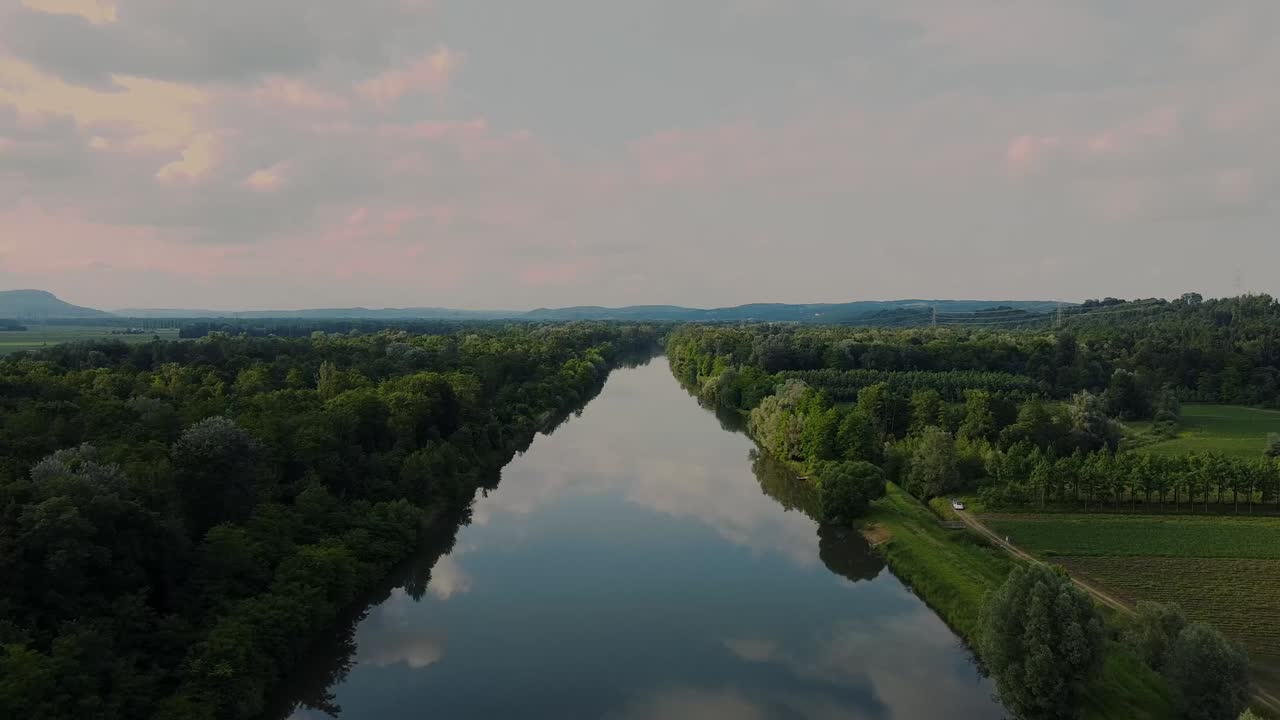 Droneoptagelse af floden Mur i Leinitz, Østrig, fra oven med vandrefleksion og en omgivende skov.