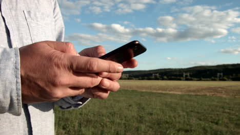 Blick-Auf-Eine-Hand,-Die-Mitten-In-Der-Natur-Ein-Handy-Hält