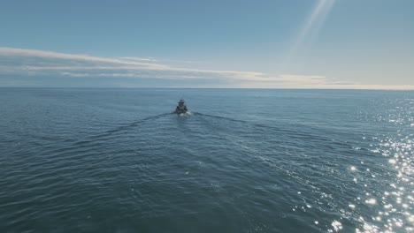 Aerial-view-of-fishing-boat-motoring-in-the-clear-calm-ocean