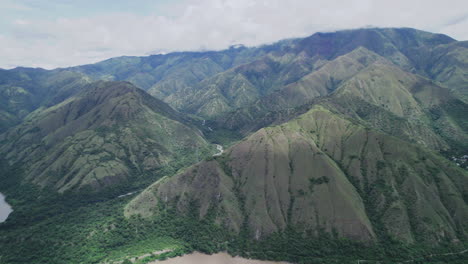 aerial-view-of-a-vast-mountain-landscape-with-billowing-clouds-in-the-background