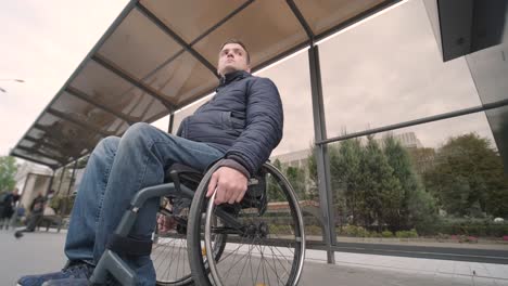 person with a physical disability waiting for city transport with an accessible ramp