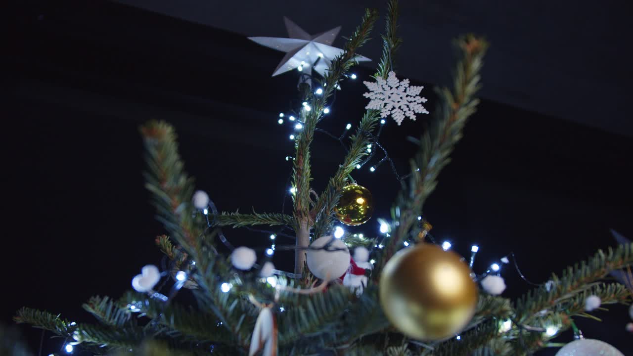 colgando burbuja dorada de navidad en el árbol de navidad oscuro 4k