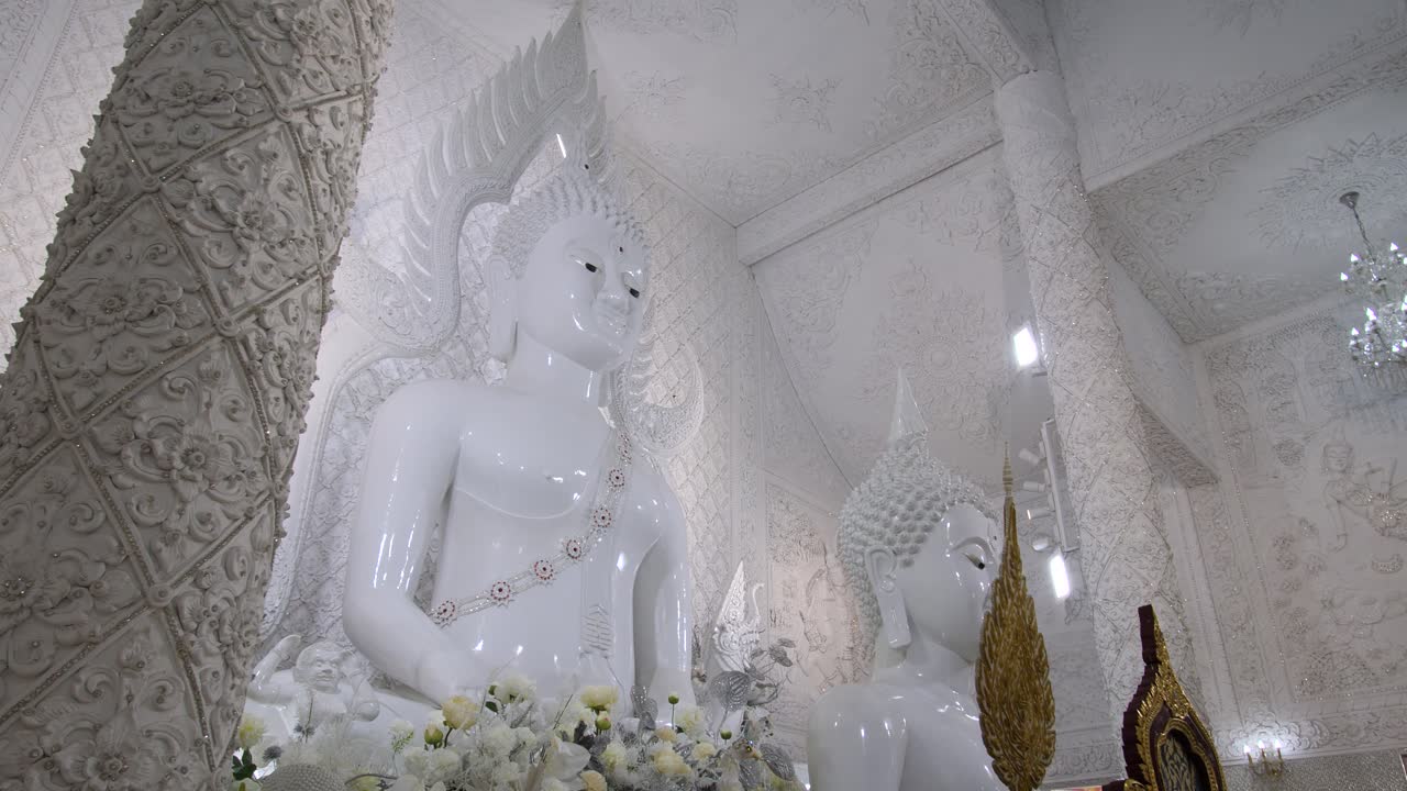 Imponenti statue bianche di grandi dimensioni al Wat Huay Pla Kang, tempio buddista a Chiang Rai, in Thailandia. Scatto dal basso