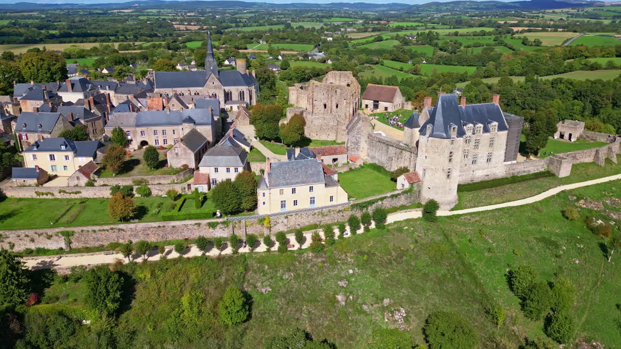 Medieval castle grounds with tower and rural landscape in background, aerial establishing overview