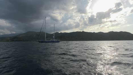 Sailboat-seen-from-speed-boat-navigating-fast-in-Northern-Corsica,-France