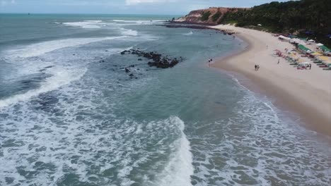 pan a lo largo de la playa brasileña en agua azul agua y playas de arena blanca junto al acantilado