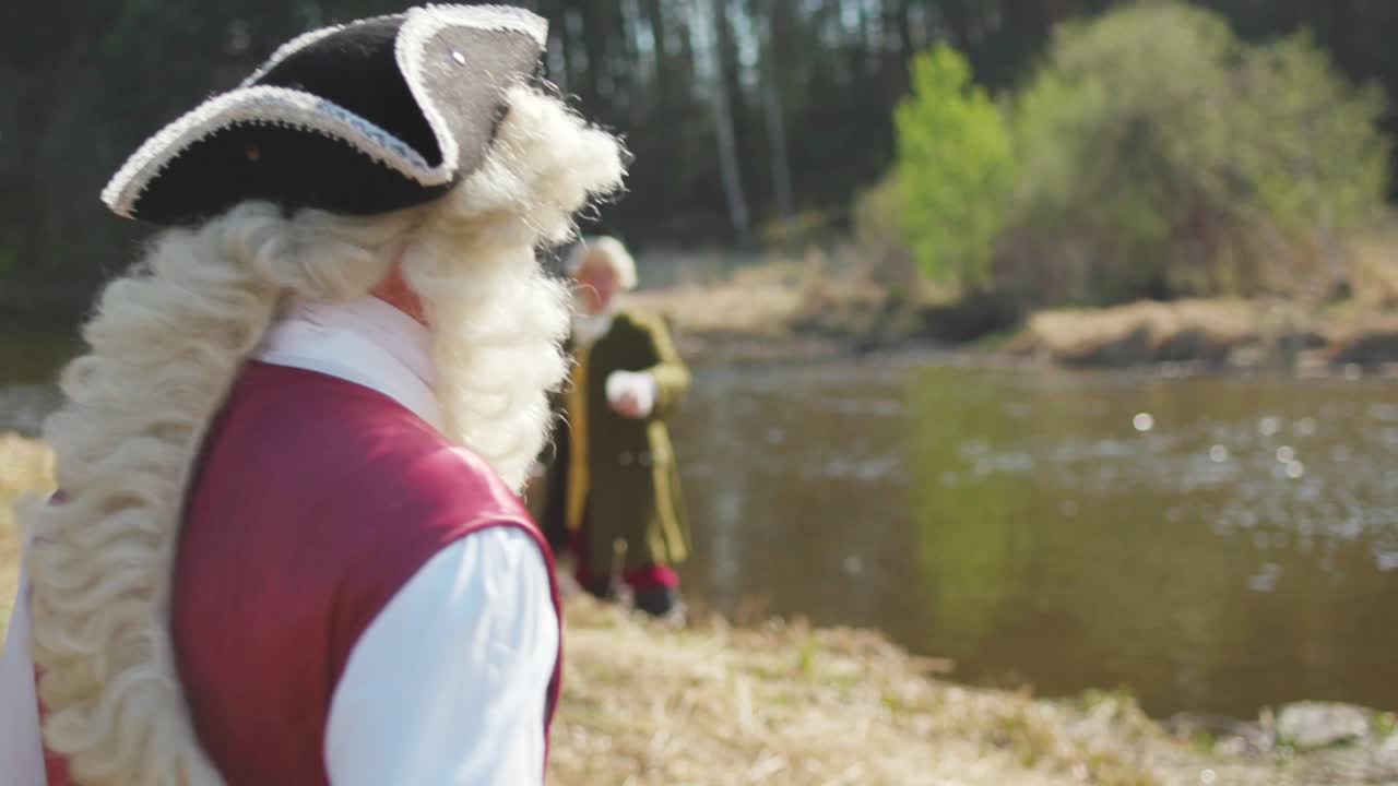 Muž v pirátském kostýmu u řeky