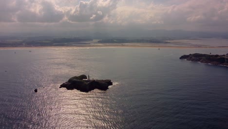 Vista-Aérea-De-La-Ciudad-De-Santander-En-España-Región-De-Cantabria,-Puerto-Y-Faro-En-La-Pequeña-Isla-Durante-La-Puesta-De-Sol-Nublada