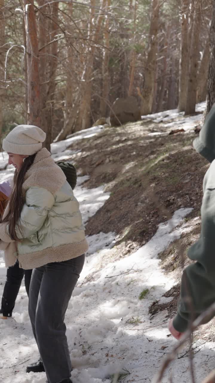 People having a snowball fight in the forest