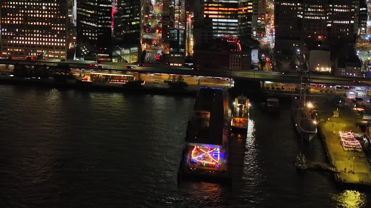 Colorful lights illuminate the waterfront in New York City at night
