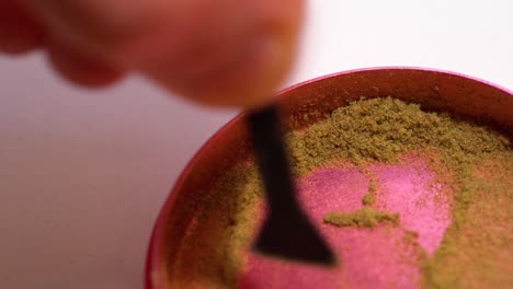 scraping keef from the bottom of marijuana grinder