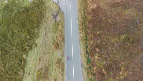 following a cyclist on a road through the mountains in ireland