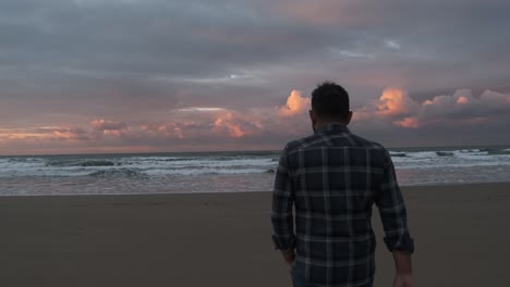 man walking on the beach at sunset