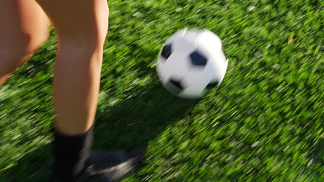 Close-up-on-the-cleats-of-a-soccer-player-running-with-a-football-dribbling-up-the-grass-field-to-score-a-goal-and-win-the-game