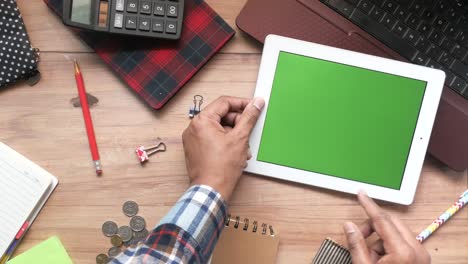 persona que trabaja en una tableta con pantalla verde, área de trabajo