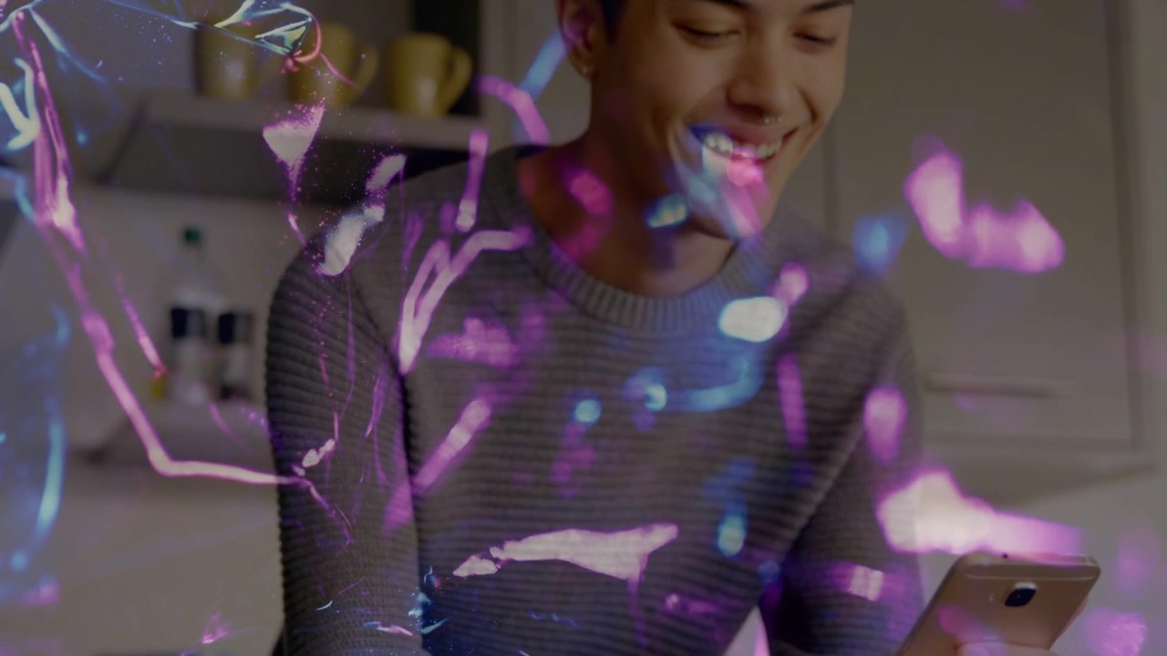 Man tapping gold phone and sparking purple-pink overlay camera rising showing smile in kitchen tech