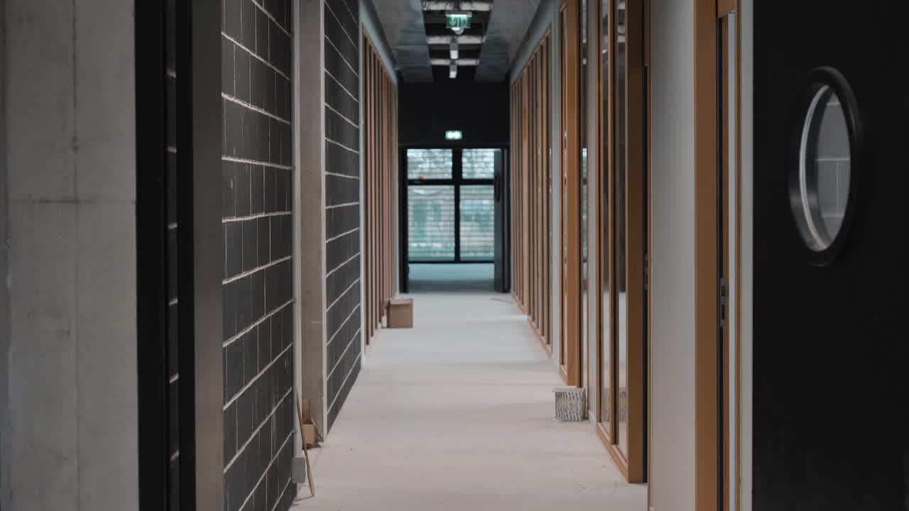 dolly shot through an office corridor with private work rooms to each side