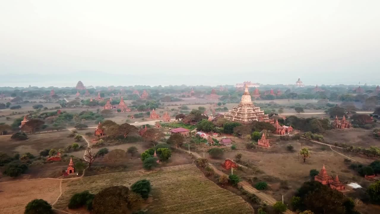 Aerial view captures the vast expanse of Bagan archaeological zone in Myanmar, showcasing numerous ancient temples and stupas amidst the morning mist, creating a mesmerizing landscape