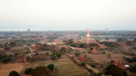 aerial view captures the vast expanse of bagan archaeological zone in myanmar, showcasing numerous ancient temples and stupas amidst the morning mist, creating a mesmerizing landscape
