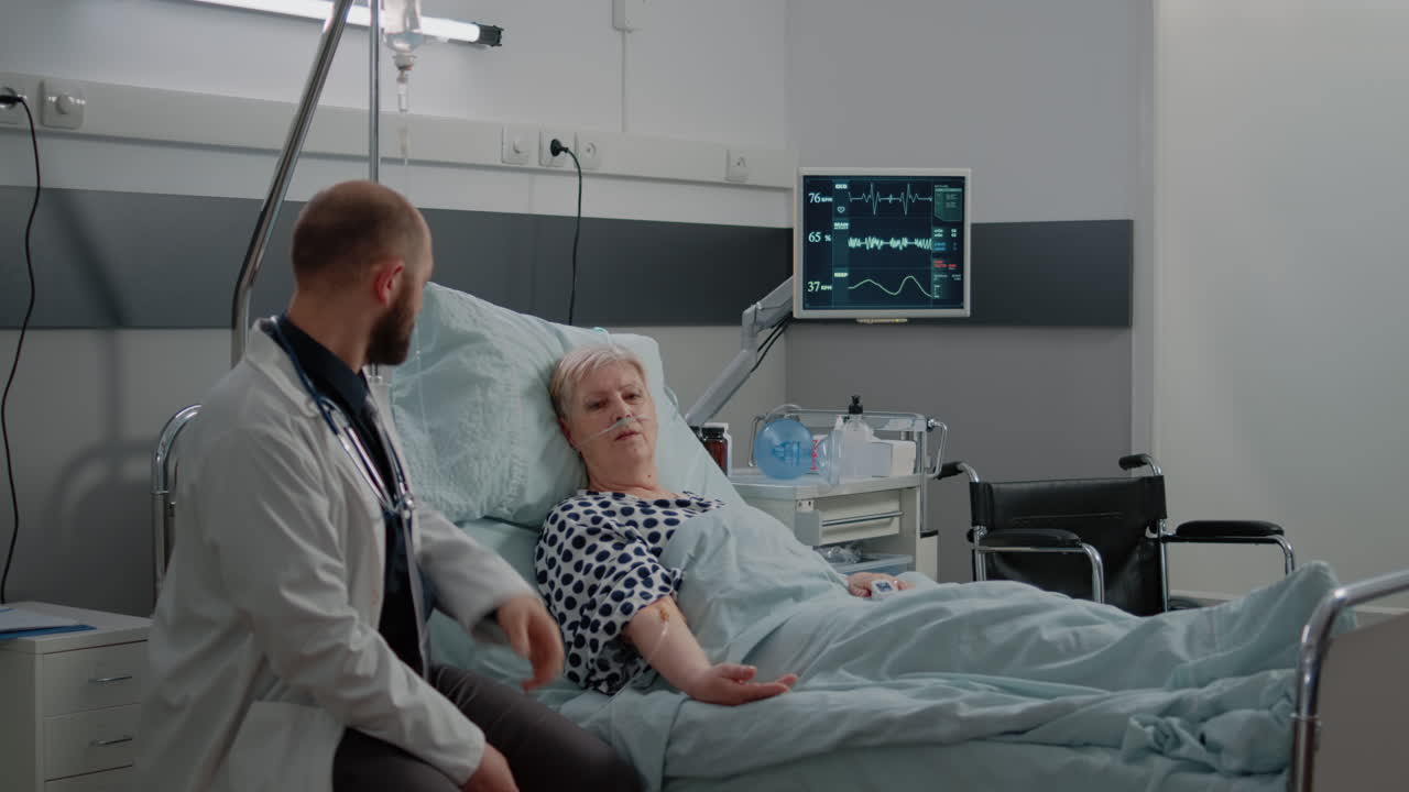 Doctor and nurse checking on elder patient in hospital ward bed