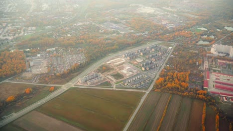 Drone-shot-out-of-a-propeller-plane-during-a-flight-above-a-village-or-a-small-town,-during-a-sunset-and-golden-hour,-nice-autumn-weather,-warm-colors,-bird's-eye,-areal-shot,-skyline,-cinematic-shot