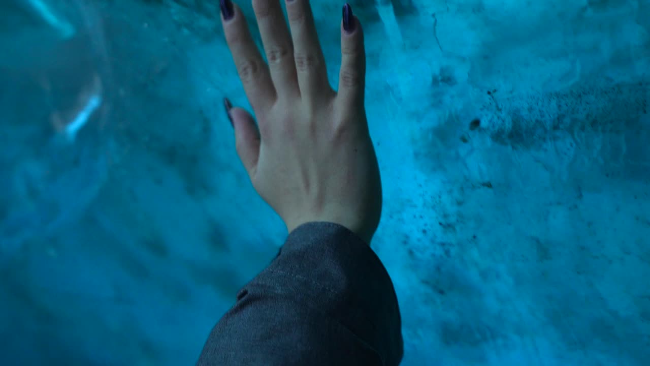 Mão tocando gelo azul