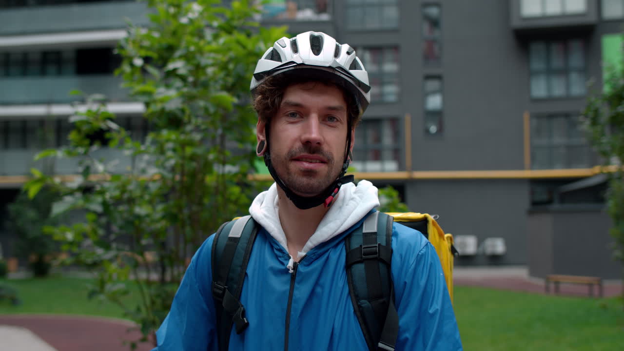 Persona de reparto con casco de bicicleta y mochila