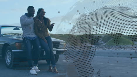 apuntando a algo, pareja apoyándose en el coche con la animación del mapa del mundo sobre ellos