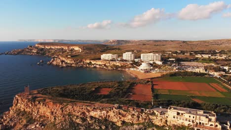 Video-Aéreo-De-Drones-De-Malta,-Que-Muestra-La-Bahía-Dorada-Y-Los-Alrededores-Antes-Del-Atardecer-En-Invierno