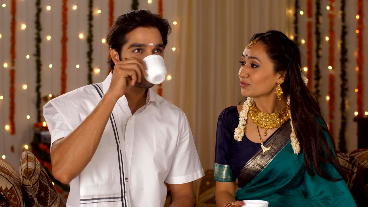 South-Indian couple in a traditional dress on  Diwali - celebrating together with a cup of hot coffee