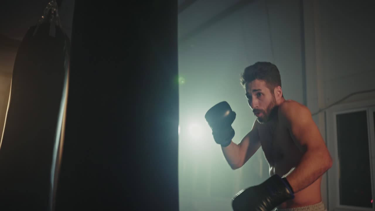 Uomo che colpisce un sacco da boxe