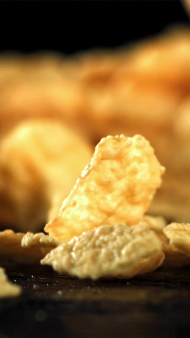 Golden Cornflakes Falling in Slow Motion on a Dark Background