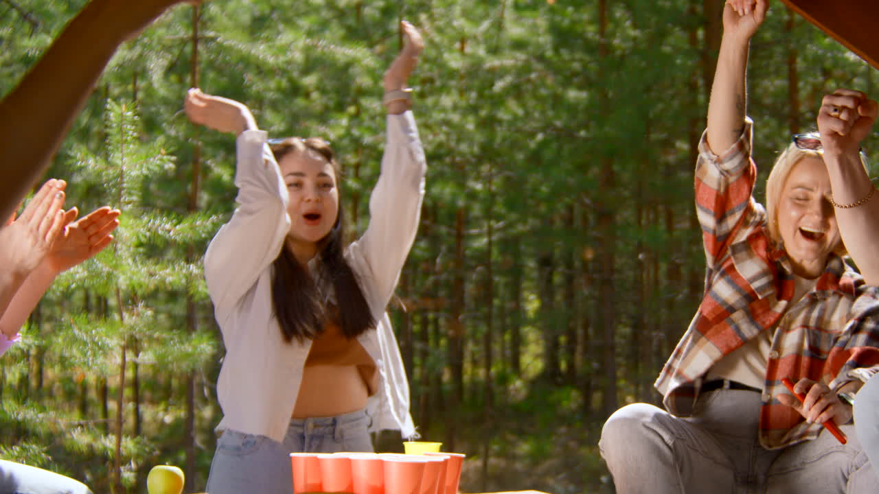 Friends Having Fun Playing Beer Pong Outdoors
