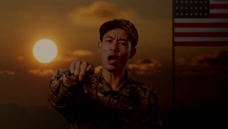 soldier pointing at sunset with american flag in the background