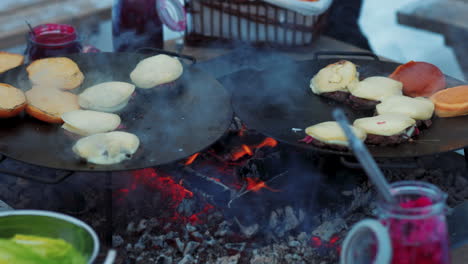 Steaming-flame-grilled-reindeer-cheese-burgers-and-buns-toasting-on-Swedish-barbecue