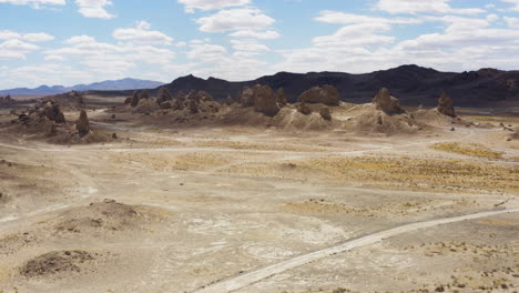 Aerial-flyover-of-towering-tufa-formations-in-morning-light-at-Trona-Pinnacles,-California