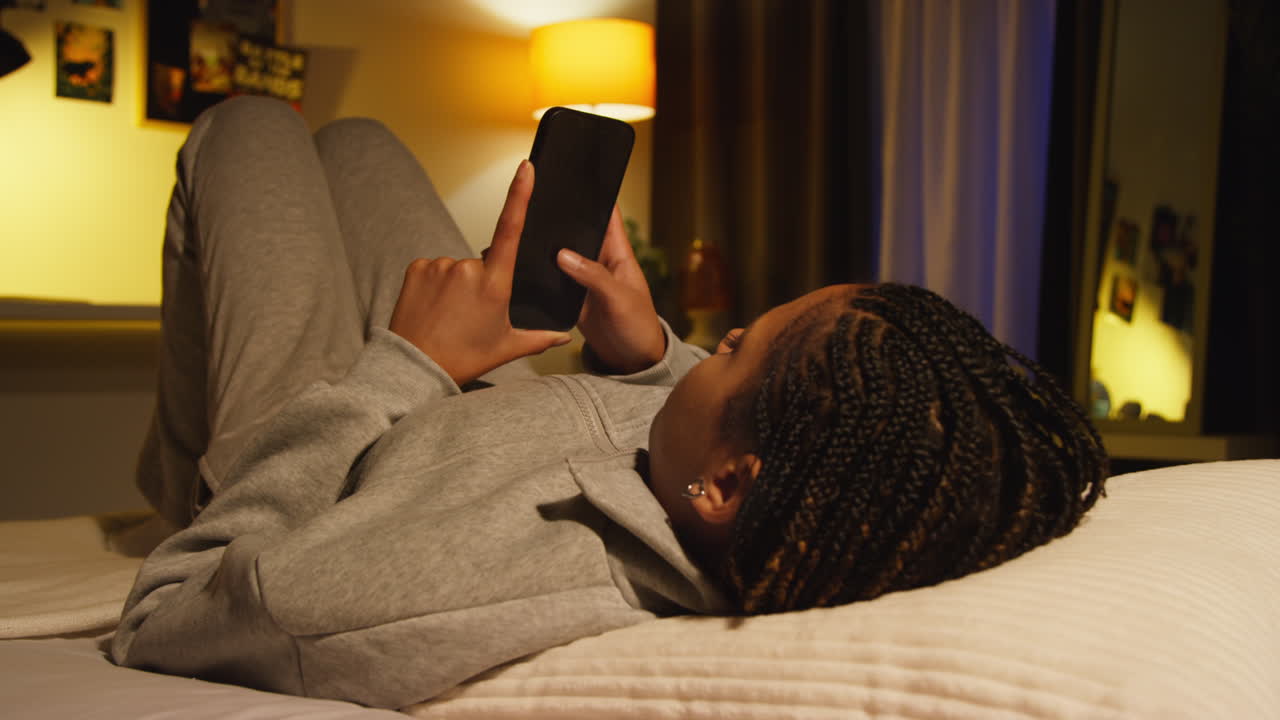 Woman Using Phone in Bed at Night